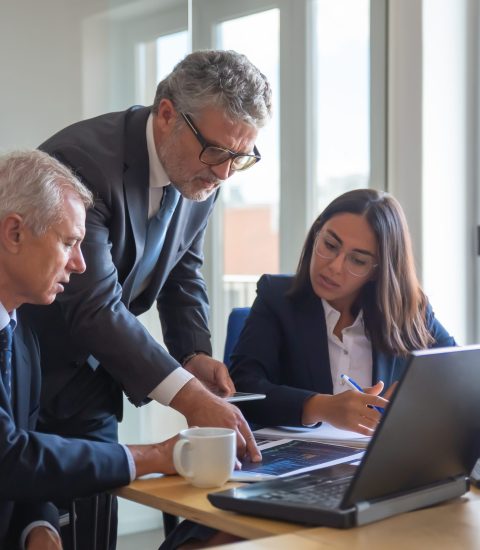 Concentrated colleagues watching statistic charts and talking